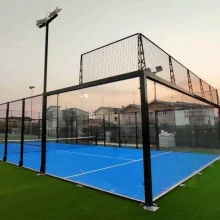 Glass-walled outdoor padel court with a blue surface near homes, part of the rise of padel